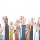 multiracial group of hands raised