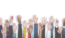 multiracial group of hands raised