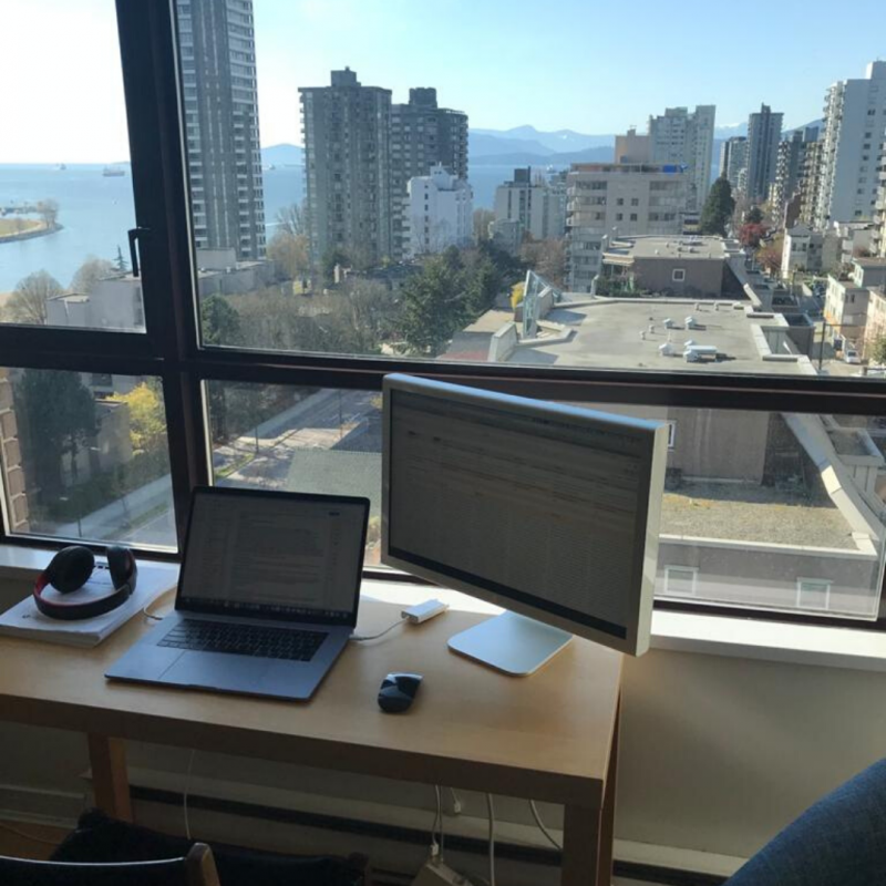 Picture of a computer desk against a window with ocean view