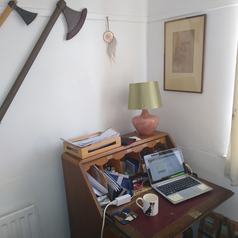 Picture of a desk with axes hanging over it