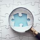 Image of a magnifying glass looking at a missing puzzle piece