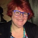 Image of Catherine Marshall, a white woman with red hair and blue glasses, who is smiling