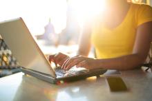 Person on laptop outside in sunshine