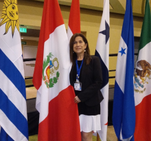 Patricia standing in front of national flags