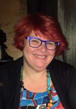Image of Catherine Marshall, a white woman with red hair and blue glasses, who is smiling