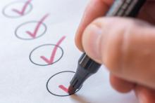 image of a hand making checks on a checklist