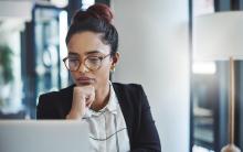 image of a woman wearing glasses and looking at a computer screen