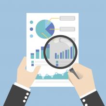 Drawing of hands holding a magnifying glass to a sheet of paper with graphs on it