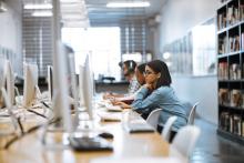 People sit at computers in a library