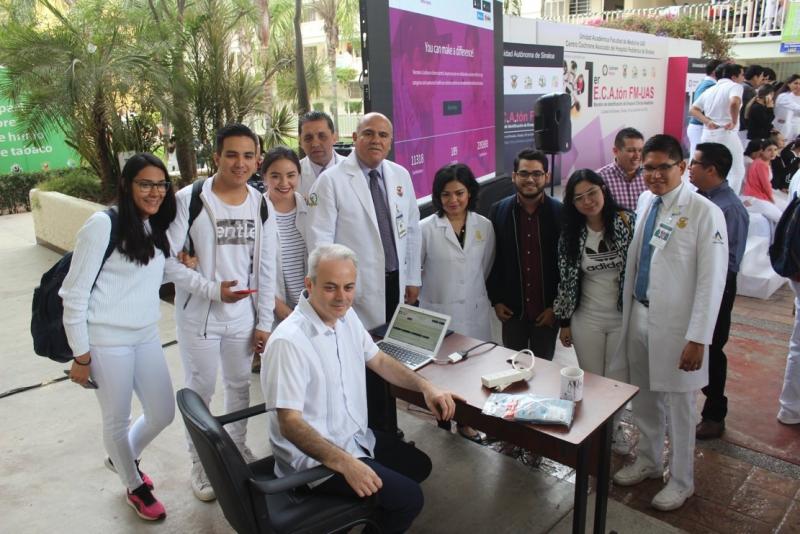 Giordano Perez-Gaxiola (seated), Dr. Gerardo Alapizco, dean of the UAS Medical Faculty, (standing behind Giordano) and students at the challenge launch event. The Cochrane Crowd screen can be seen behind.