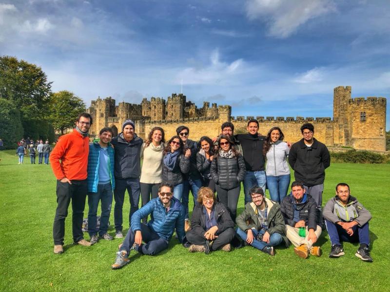 A group of people stand in front of a castle 