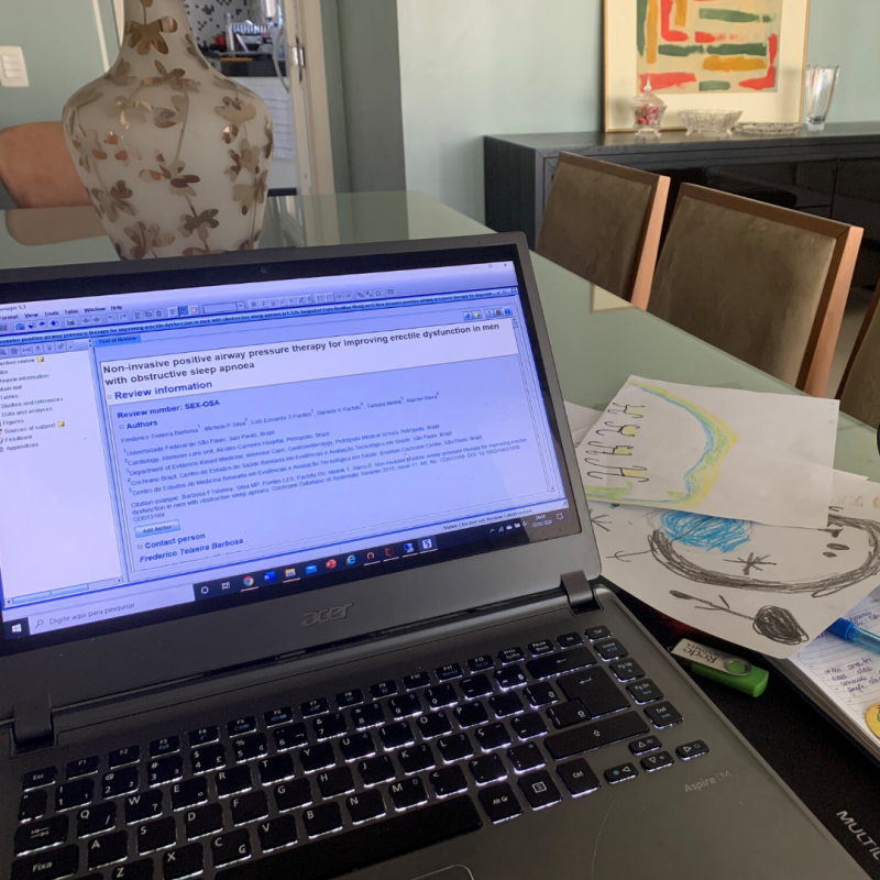 Photo of a table with a computer and children's drawings next to it